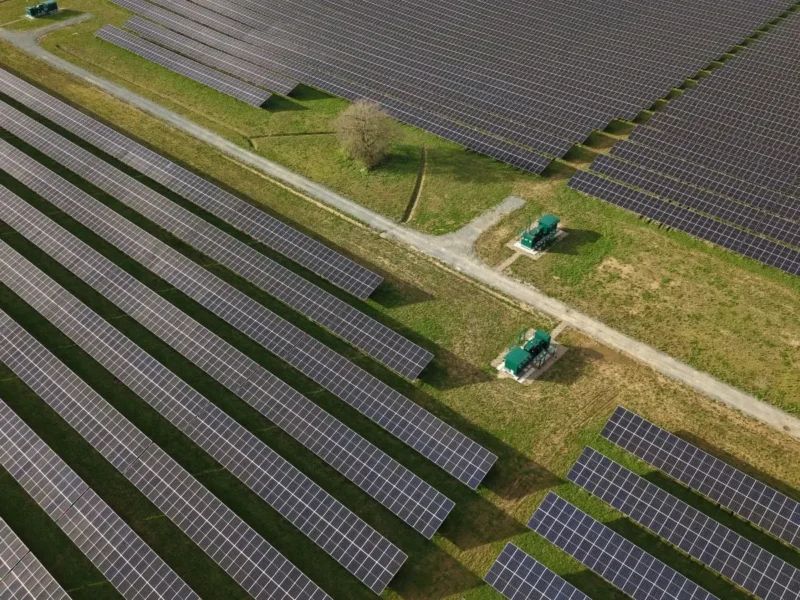 Aerial drone view of solar panels and green BESS battery storage units in a rural UK field